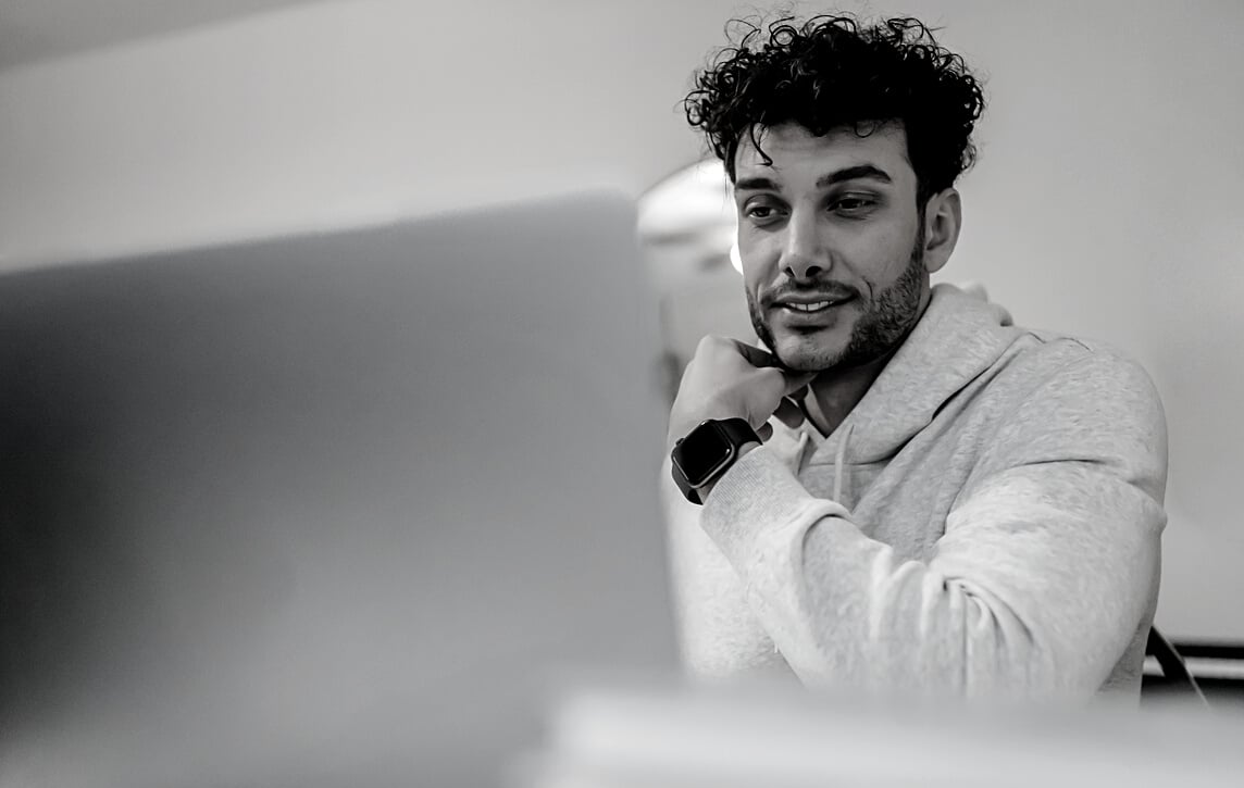 Smiling distance employee in smart watch against laptop at home